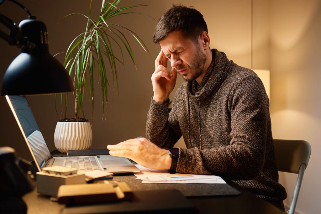 Founder feeling overwhelmed while managing HR tasks and paperwork at a desk.